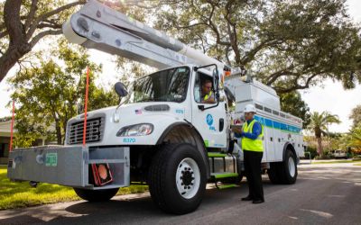 Man in bucket truck talks to man with hard hat