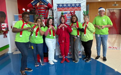 People in festive clothing making heart gesture 