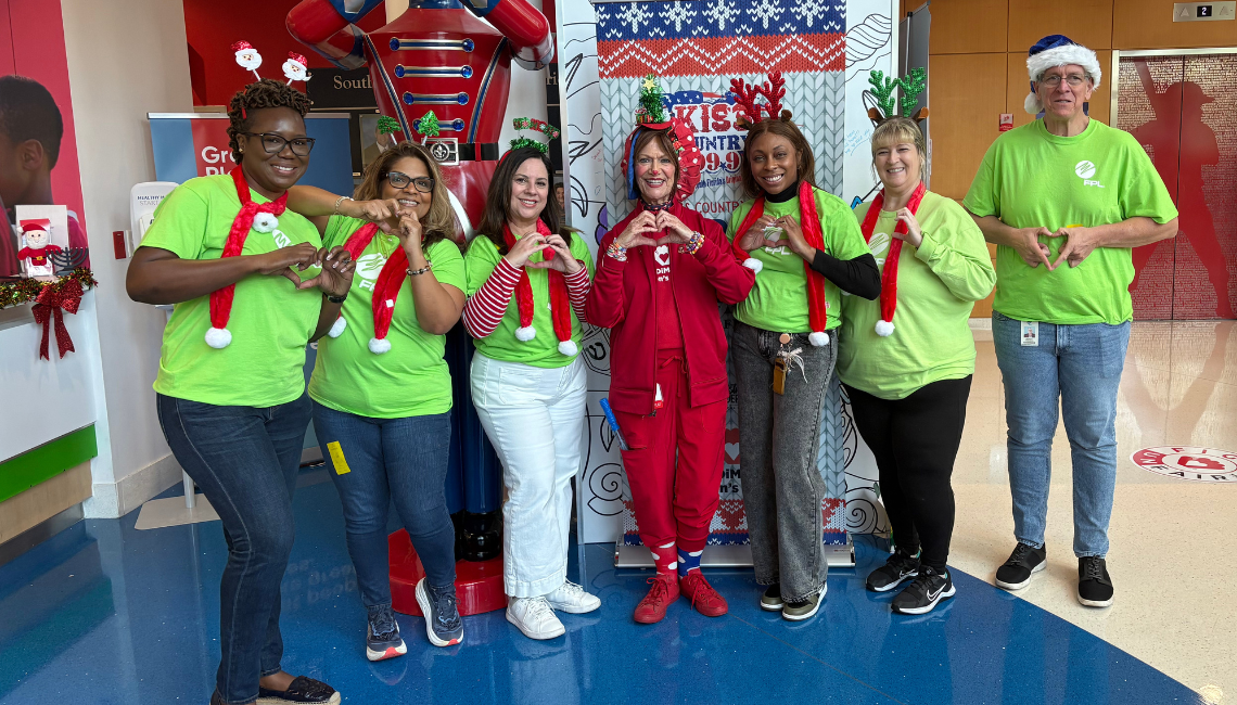 People in festive clothing making heart gesture 